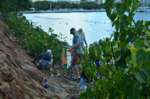 A few people picking up trash oceanside